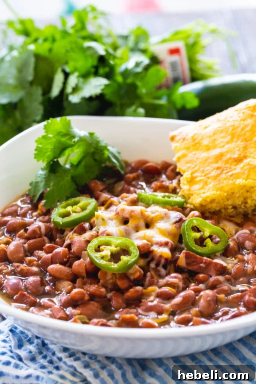 Hearty Slow Cooker Spicy Pinto Beans 4 Slow Cooker Spicy Pinto Beans in a white bowl with cornbread.