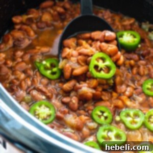 Spicy Pinto Beans in a crock pot with jalapenos on top