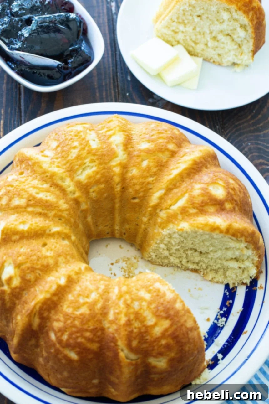 Sally Lunn: A Classic British Bake 3 Sally Lunn Bread on serving platter with a bowl of grape jelly, highlighting its versatility.
