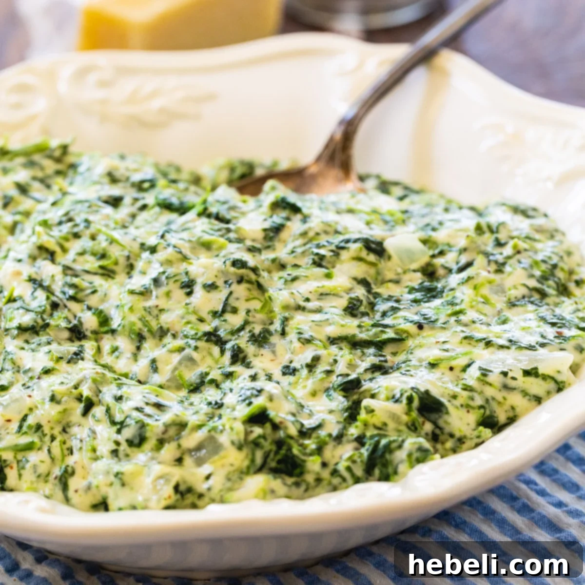 Velvety Creamed Spinach 2 Creamed Spinach in a bowl with a spoon, highlighting its creamy texture.