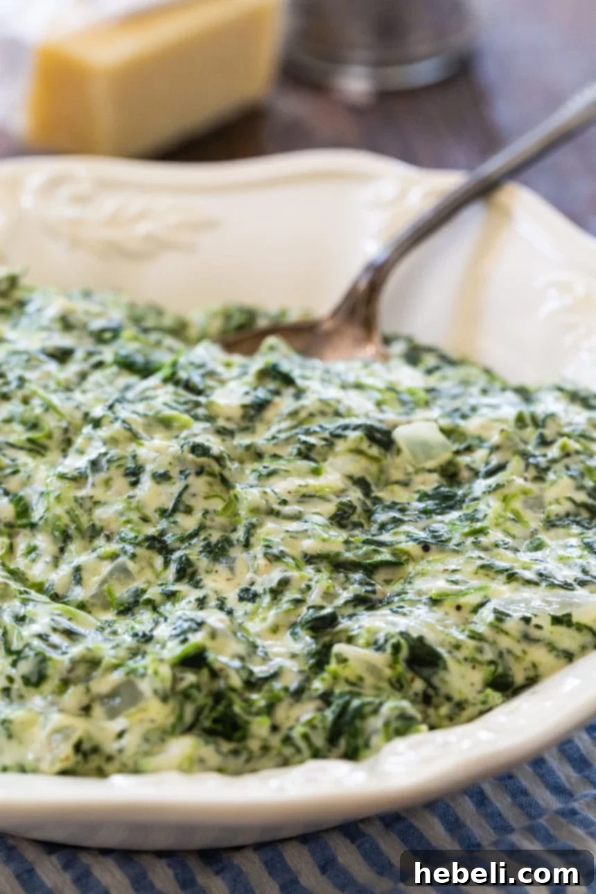 Velvety Creamed Spinach 4 Creamed Spinach served in a white bowl, ready to be enjoyed.
