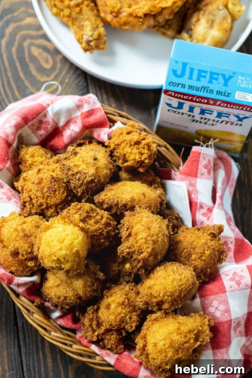 An inviting overhead shot of a rustic basket filled to the brim with freshly fried Jiffy Hush Puppies.