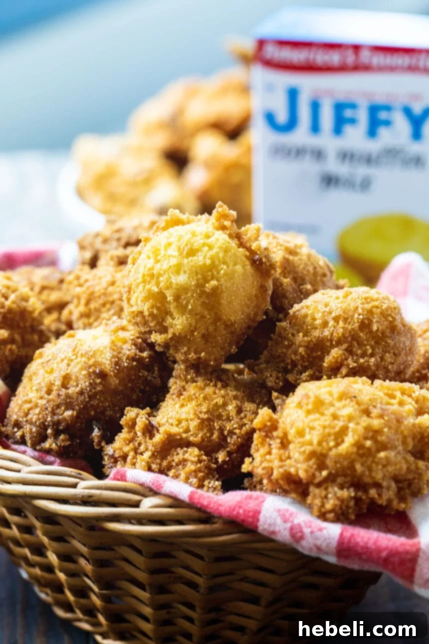 A beautifully composed shot of Jiffy Hush Puppies in a rustic basket, with a familiar box of Jiffy cornbread mix visible in the background, emphasizing the ease of preparation.