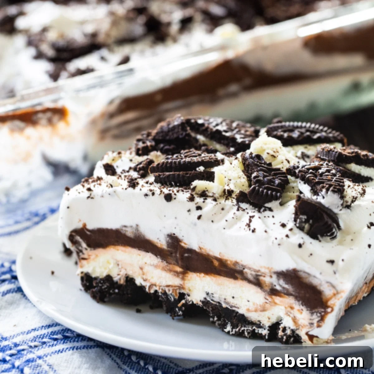 A slice of creamy Oreo Delight on a small white plate, showing its distinct layers.