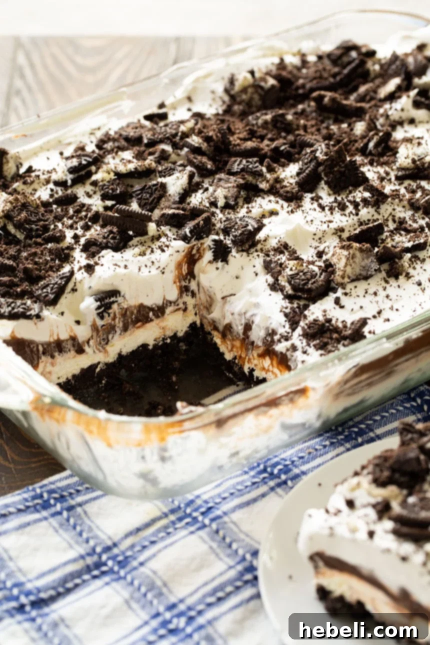 Full pan of Oreo Lush, a no-bake layered dessert, covered with whipped topping and crushed Oreos.