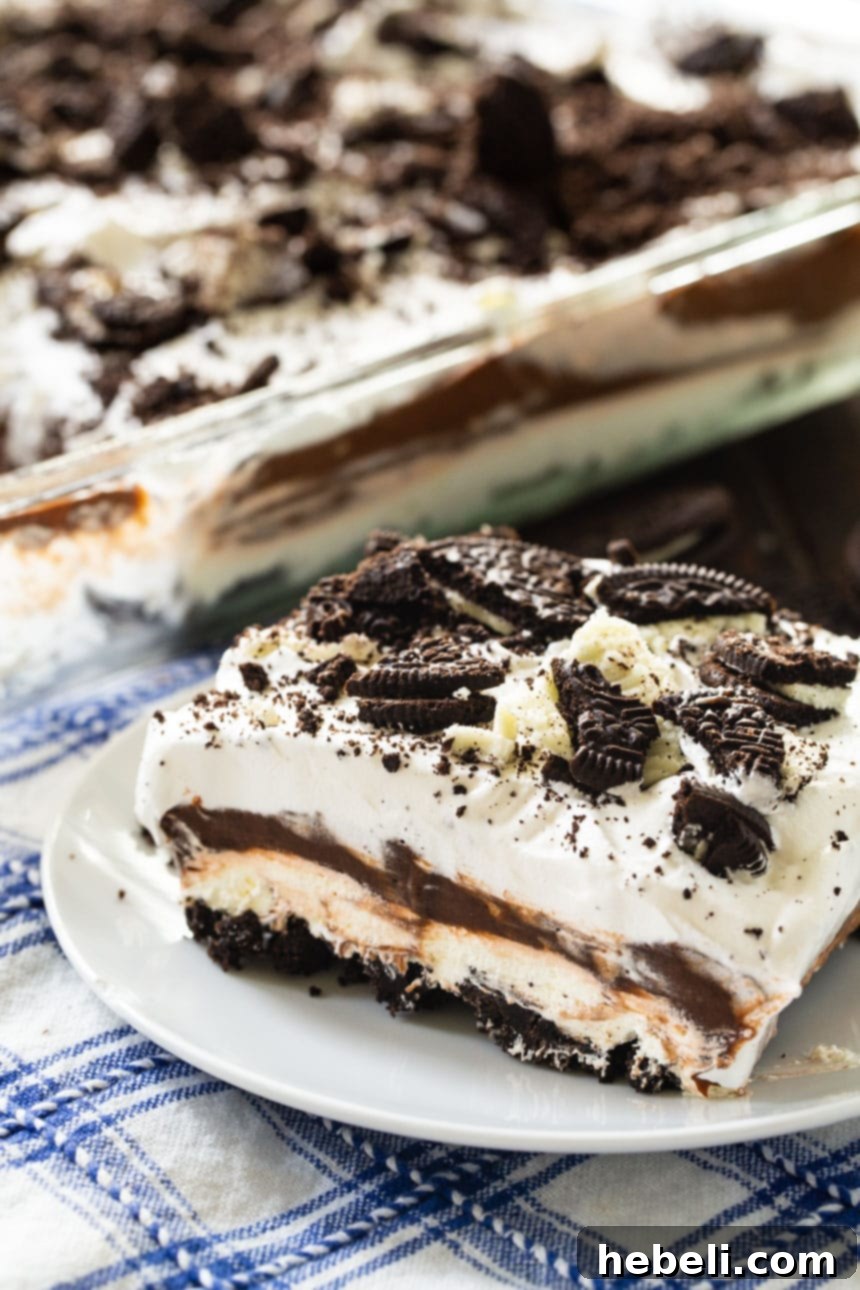 A beautiful close-up of a slice of No-Bake Oreo Lush on a plate, showcasing its four creamy layers.
