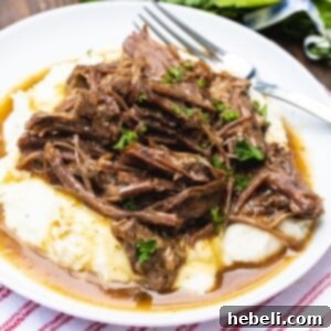 Instant Pot Pot Roast served over mashed potatoes.