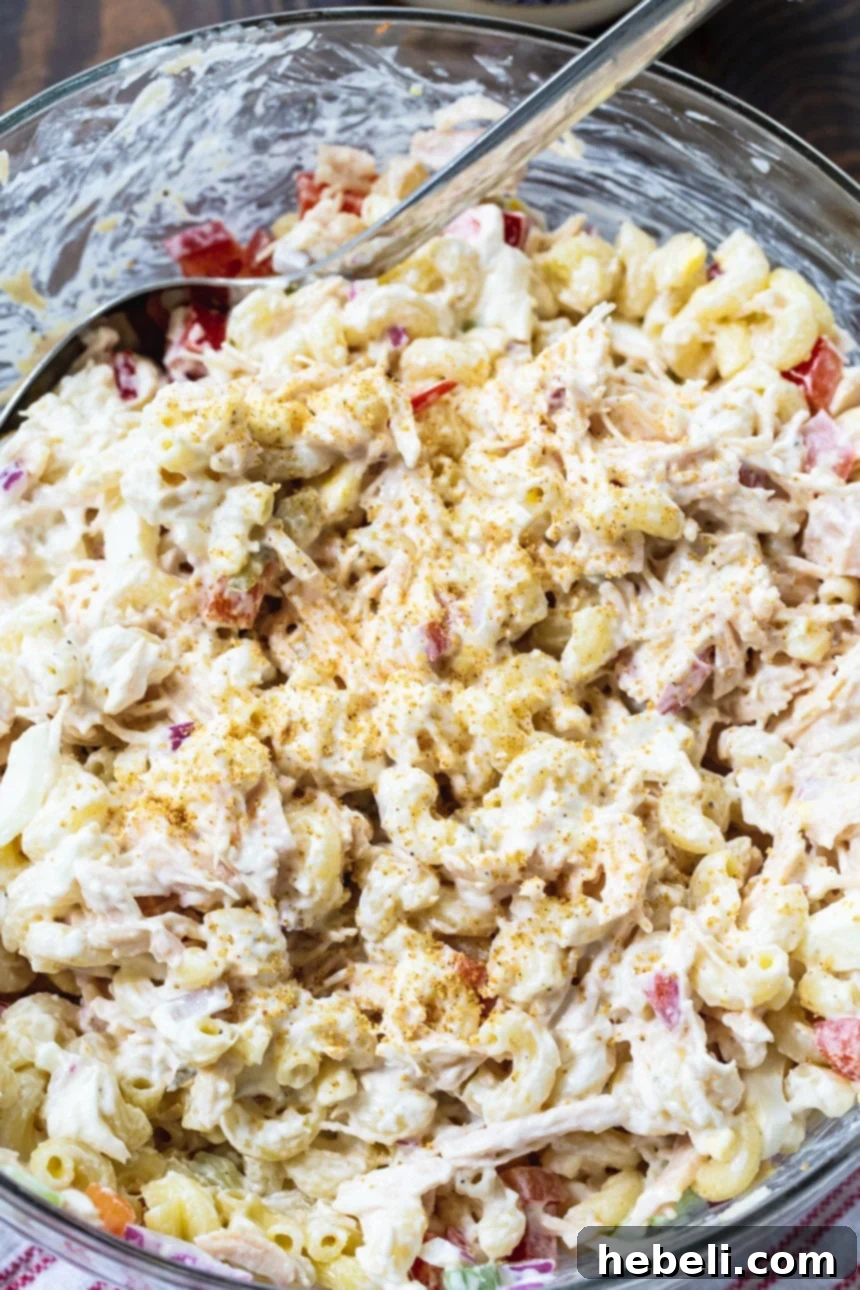 Creamy Chicken Pasta Salad 3 Close-up view of Chicken Macaroni Salad in a glass serving bowl, highlighting the creamy texture and colorful ingredients.