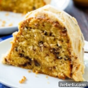 A slice of Peanut Butter Bundt Cake on a white plate, showcasing the golden cake and smooth peanut butter drizzle.