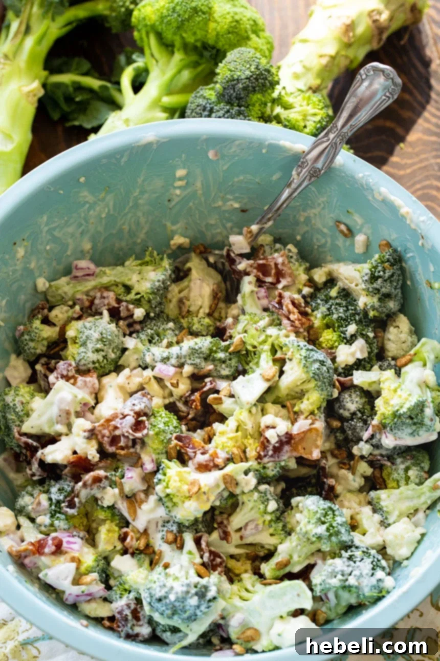 Bacon Blue Cheese Broccoli Salad in a large blue bowl, ready to be served at a gathering.