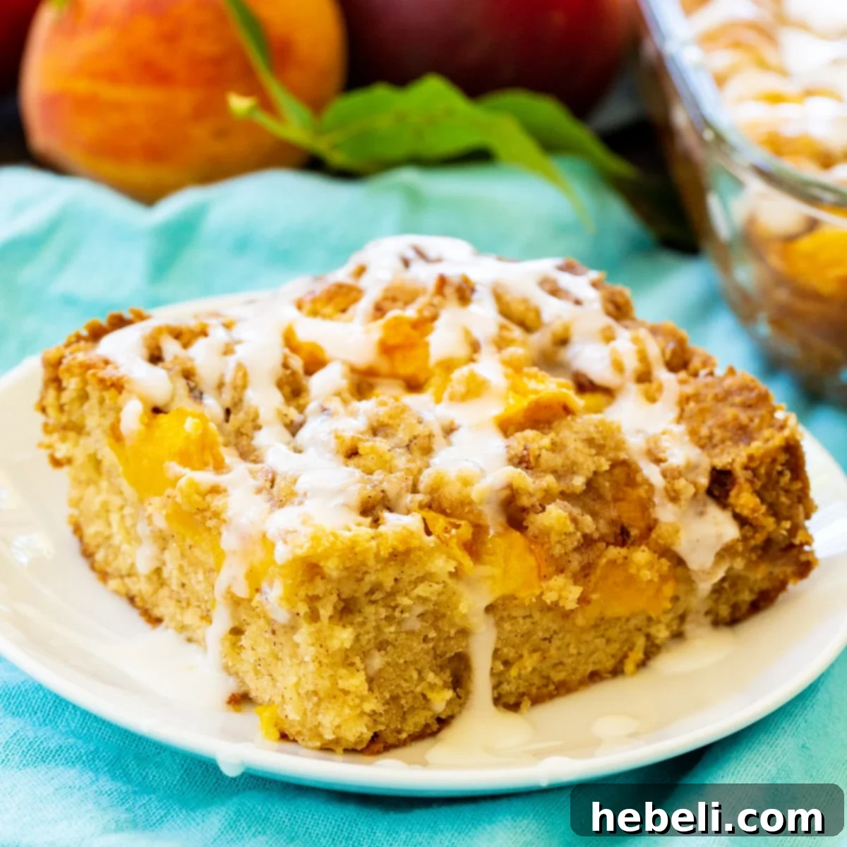 Peach Crumble Coffee Cake 2 A perfectly sliced piece of Peach Crisp Coffee Cake, showcasing its moist texture, peach layers, and streusel topping, served on a plate.