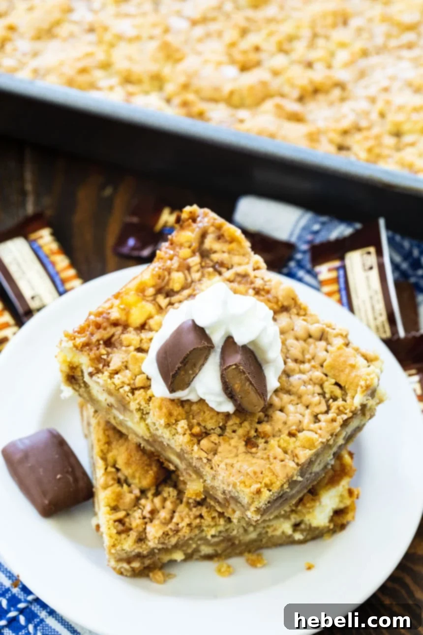 Toffee Cheesecake Bars on a plate with pan full of bars next to them, showing their generous size and tempting layers.