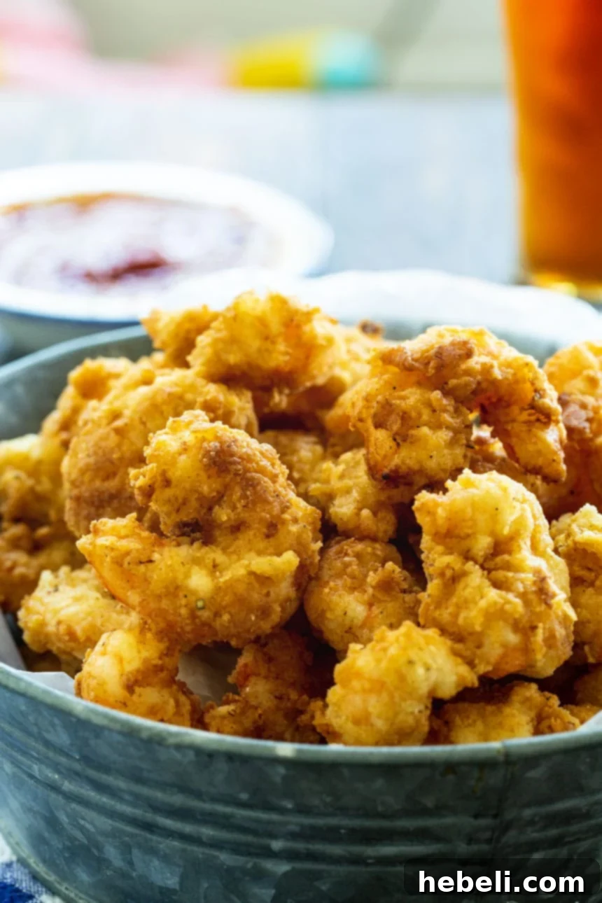 Fried Calabash Shrimp served with a beer in the background, highlighting a perfect meal.