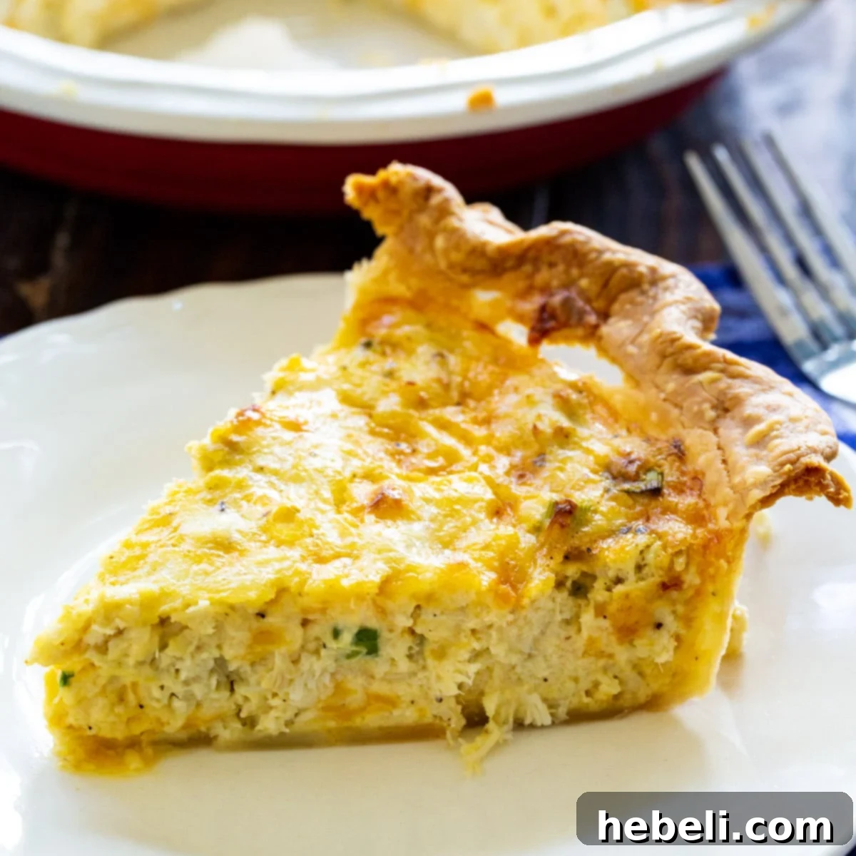 Savory Crab Pie 2 A perfectly baked slice of Crab Pie on a white plate, showcasing its golden crust and creamy filling.