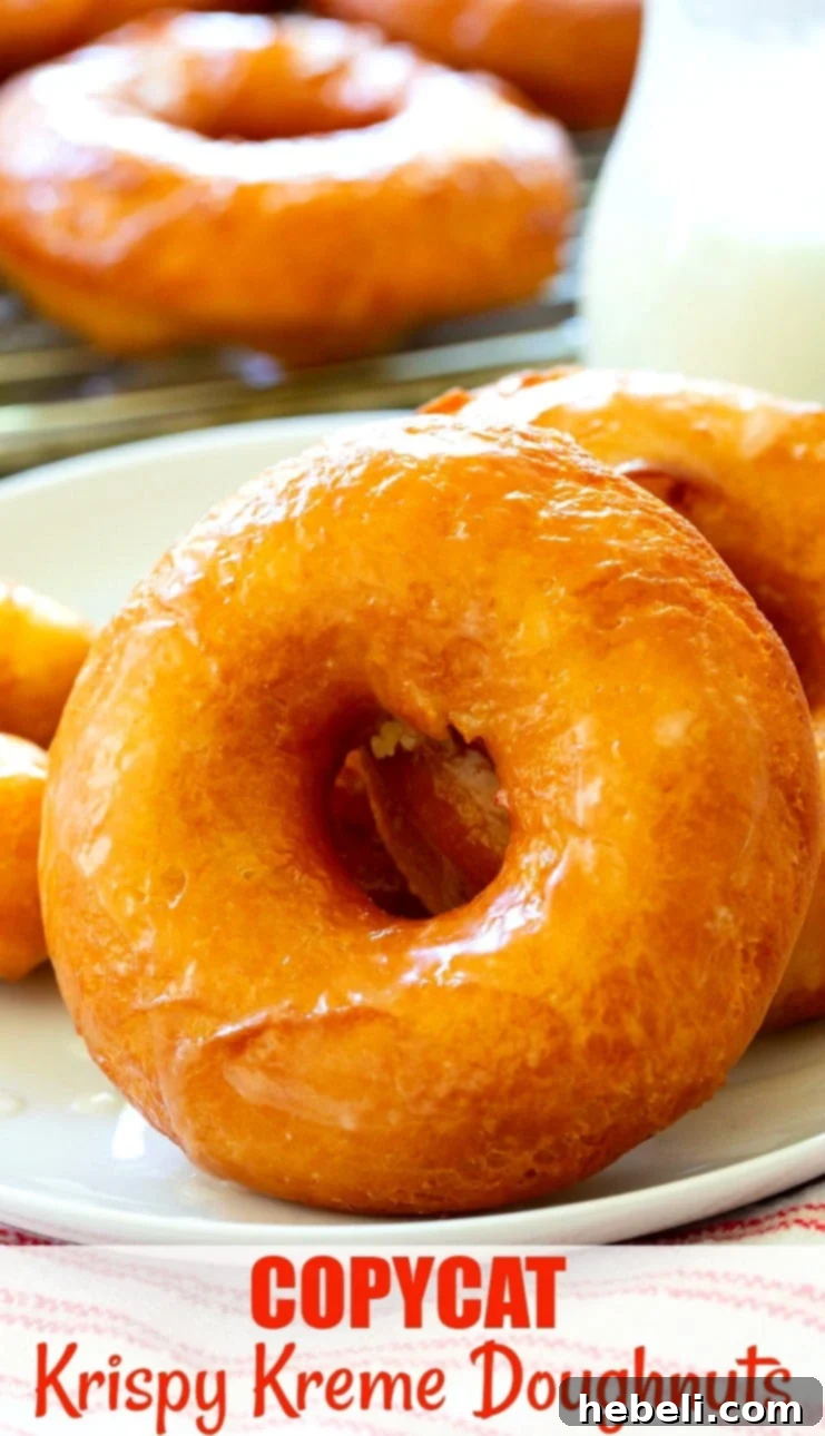Homemade Krispy Kreme Style Doughnuts 6 A tantalizing close-up shot of a single perfectly glazed Copycat Krispy Kreme Doughnut, showcasing its fluffy texture, golden color, and sweet, reflective shine.