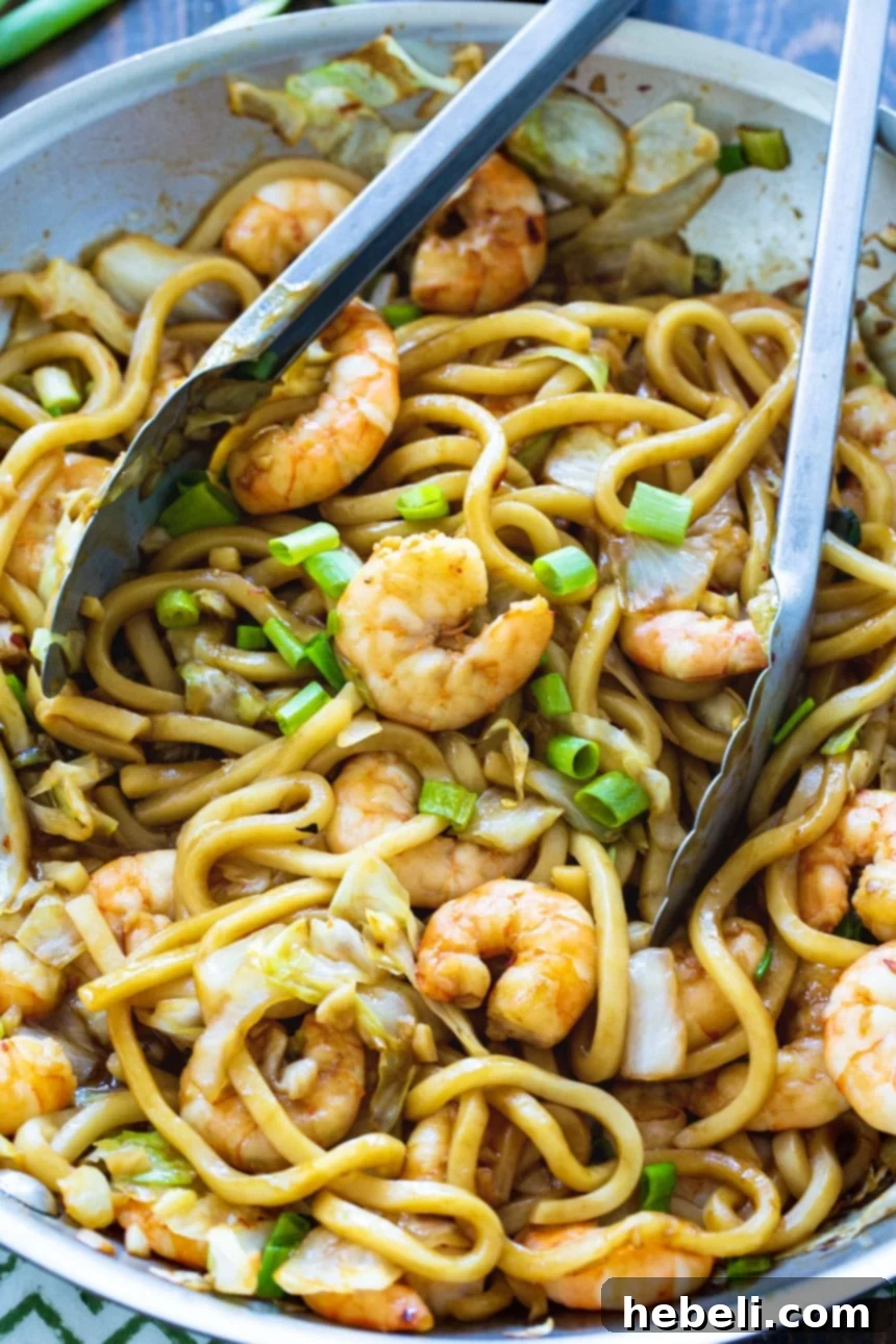 Spicy Shrimp Udon stir-frying in a large skillet