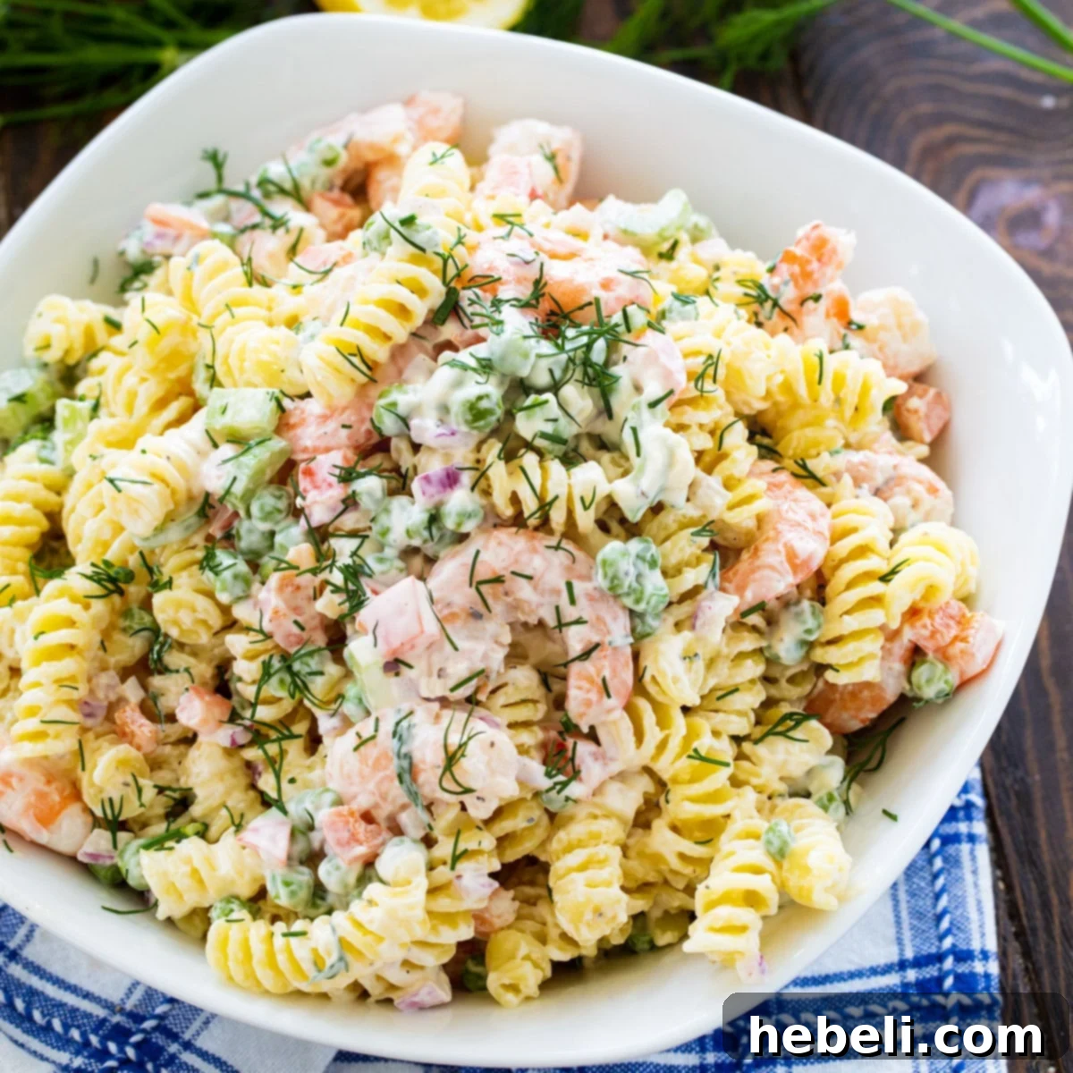 Zesty Shrimp Dill Pasta Salad 2 A large white serving bowl filled with creamy Shrimp and Dill Pasta Salad, showcasing the shrimp, pasta, and fresh dill.