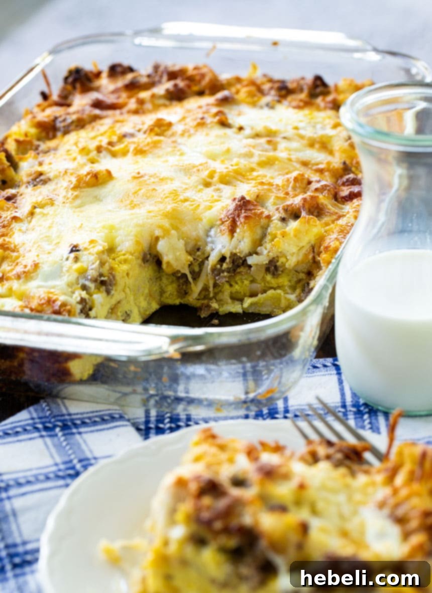 A close-up view of the golden-brown Sausage and Cheese English Muffin Breakfast Casserole fresh from the oven, showing the melted cheese, savory sausage, and visible English muffin pieces, emphasizing its appeal as a great make-ahead meal.