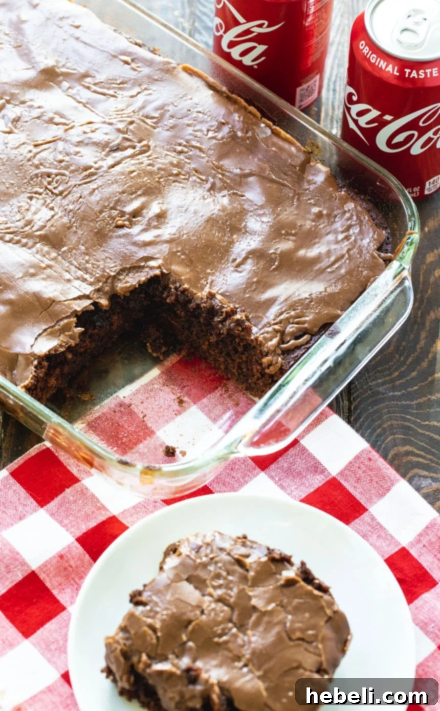 Grandma's Coca-Cola Cake 3 Baked Coca-Cola Cake in a 9x13-inch pan with a slice removed, showing its internal structure.
