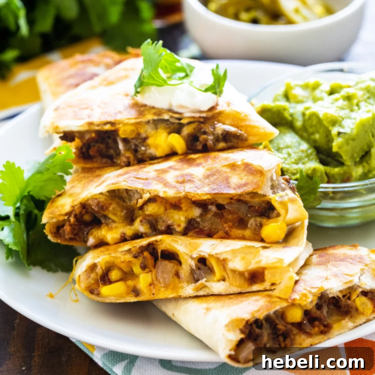 Ground Beef Quesadillas cut into wedges and piled on a plate, garnished with fresh cilantro.