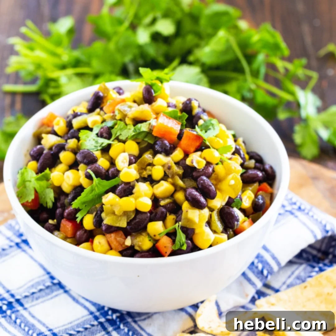Southwestern Black Bean Corn Salad 2 Black Bean and Corn Salsa in a bowl with bunch of cilantro behind it.