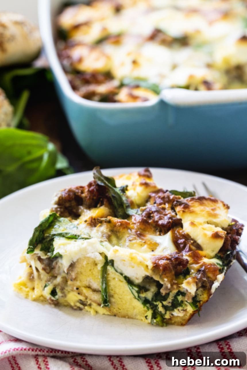 A generous serving of the Everything Bagel Breakfast Casserole on a white plate, with the full baking dish visible in the soft-focus background.