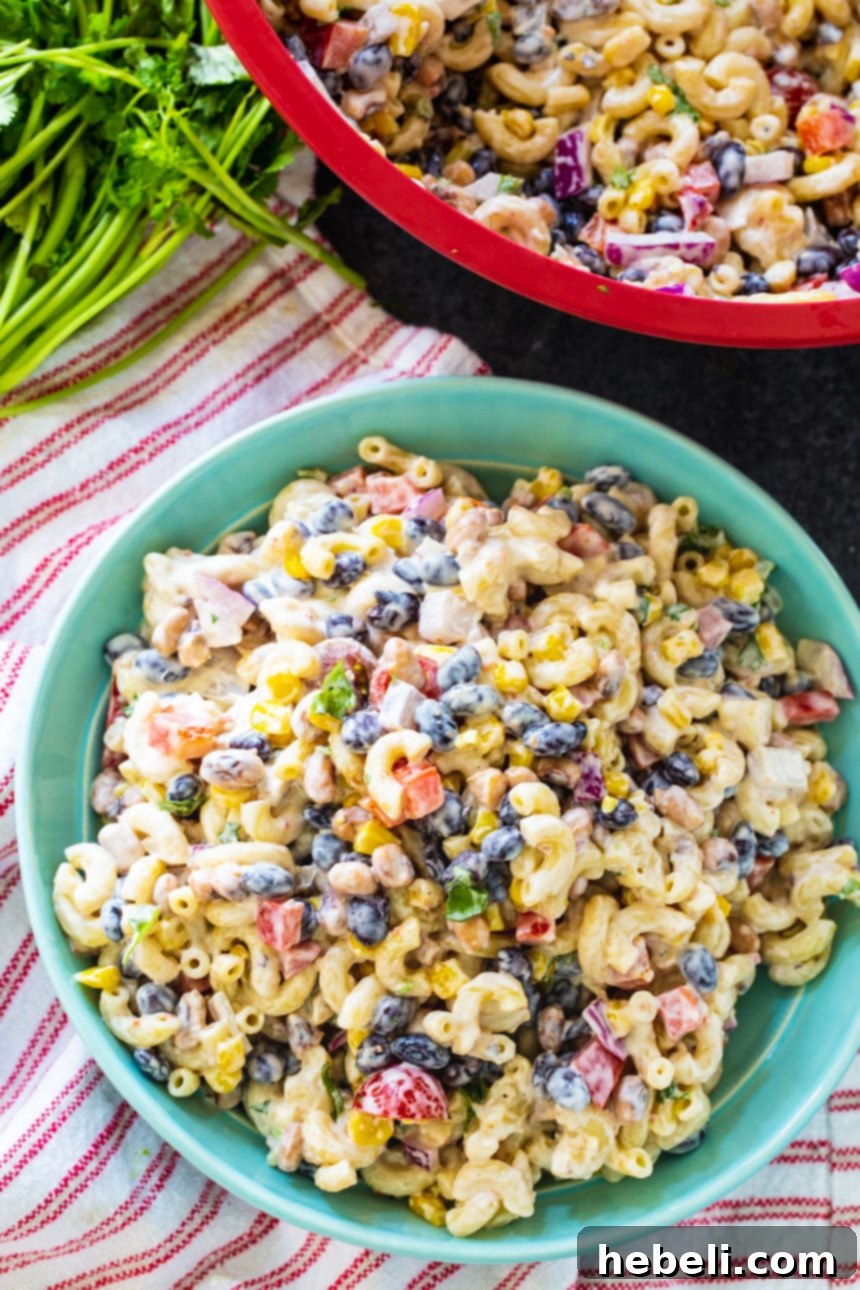Overhead shot of Texas Caviar Pasta Salad in a blue bowl, presented on a red striped kitchen towel.