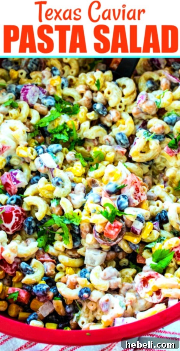 Texas Caviar Pasta Salad in a large red bowl, garnished with herbs.