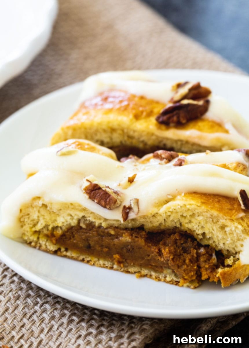 Two slices of Pumpkin Crescent Braid on a plate, showing the creamy filling and glazed top.