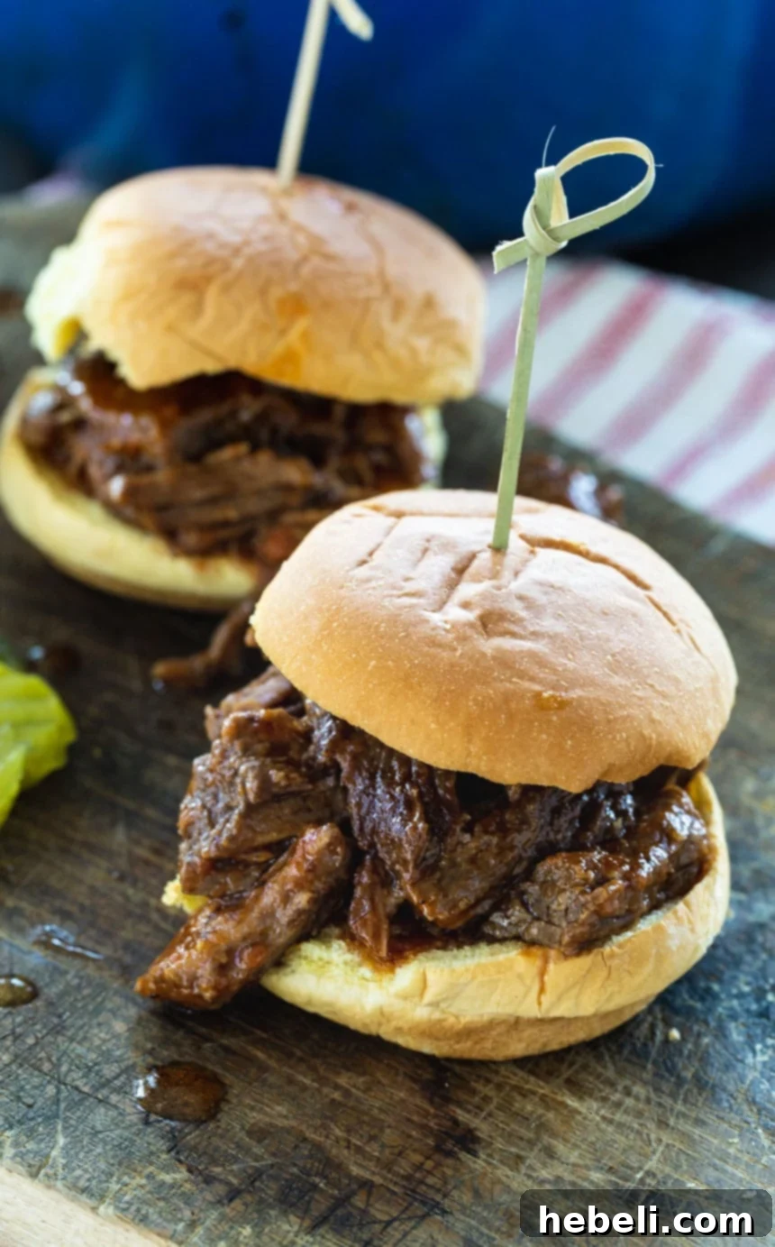 Two perfectly crafted mini BBQ Beef Sliders, presented beautifully on small buns with tender, saucy beef, ready to be enjoyed as appetizers or a light meal.