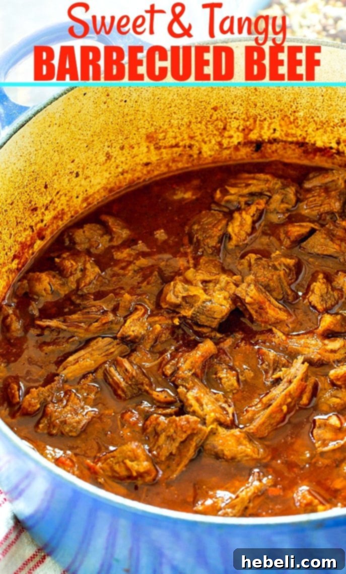 Close-up of succulent shredded Sweet and Tangy BBQ Beef, glistening with its rich sauce, served in a rustic bowl, highlighting its perfect tenderness.