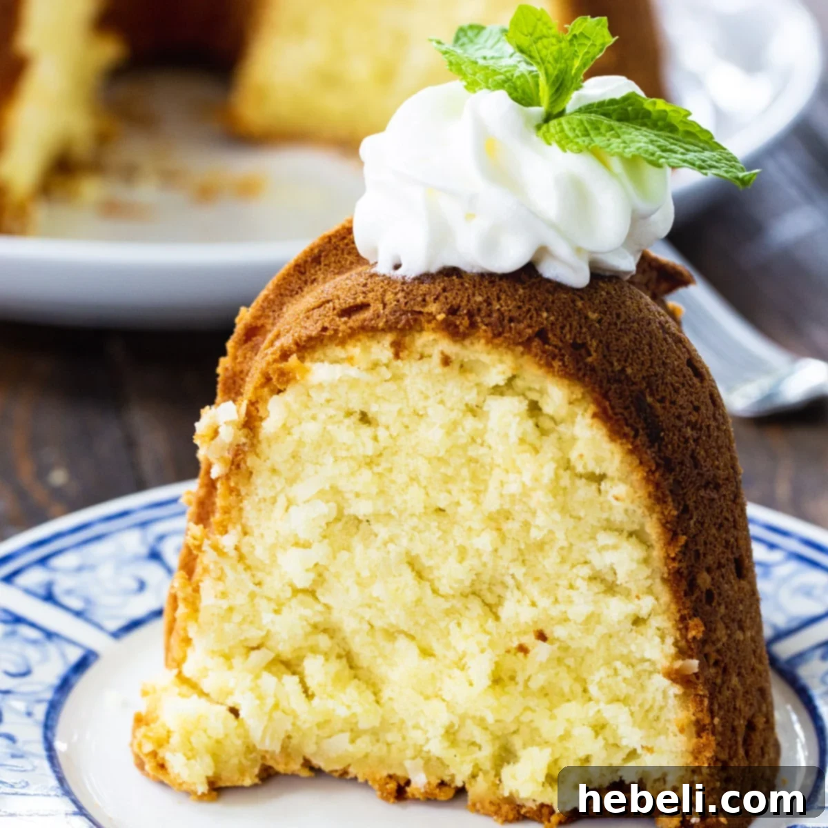 Luscious Coconut Cream Cheese Pound Cake 2 Slice of Coconut Cream Cheese Pound Cake topped with a dollop of whipped cream and a sprinkle of toasted coconut flakes.