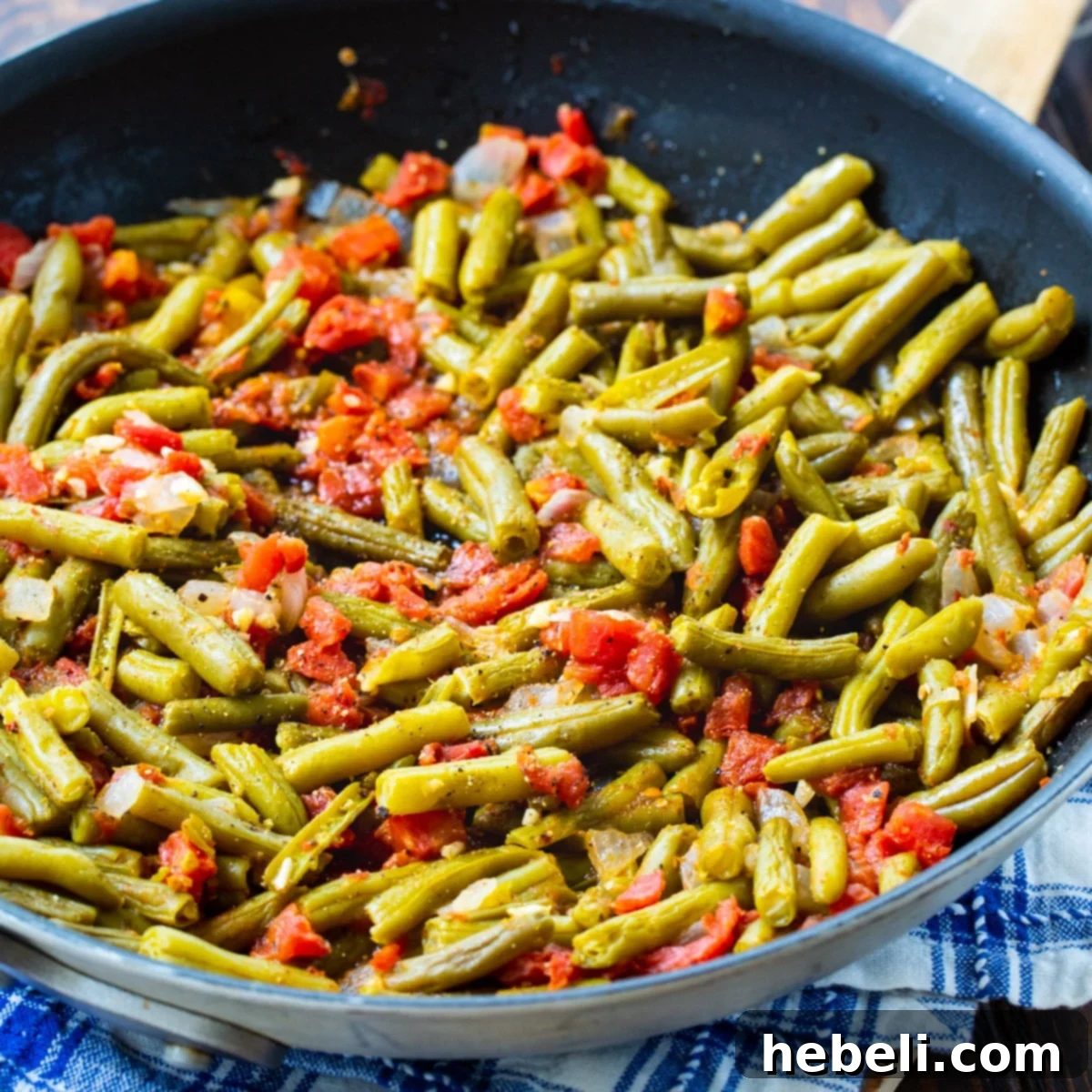 Southwestern Green Beans 2 A nonstick skillet brimming with freshly cooked Rotel Green Beans, highlighting their vibrant green and red hues.