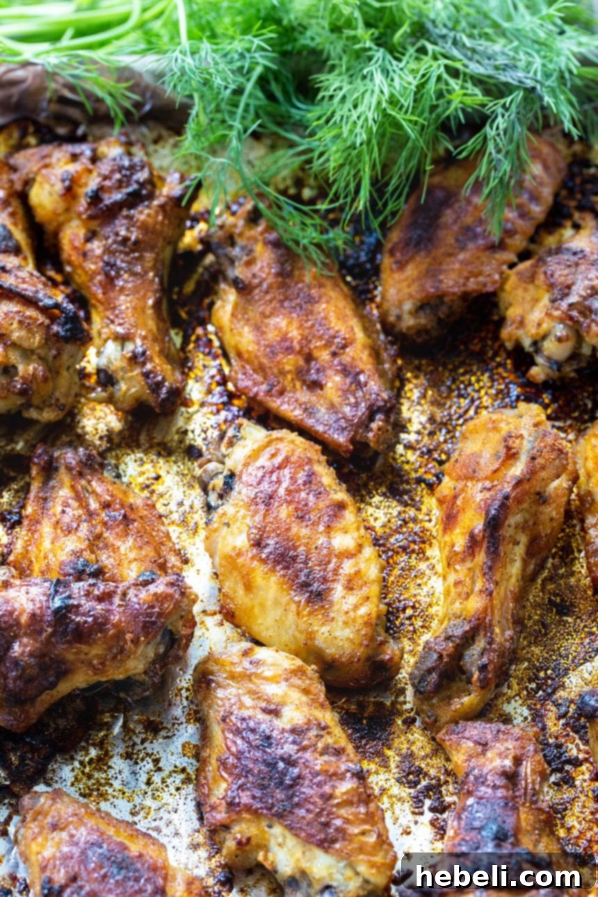 Roasted wings on baking sheet with fresh dill.