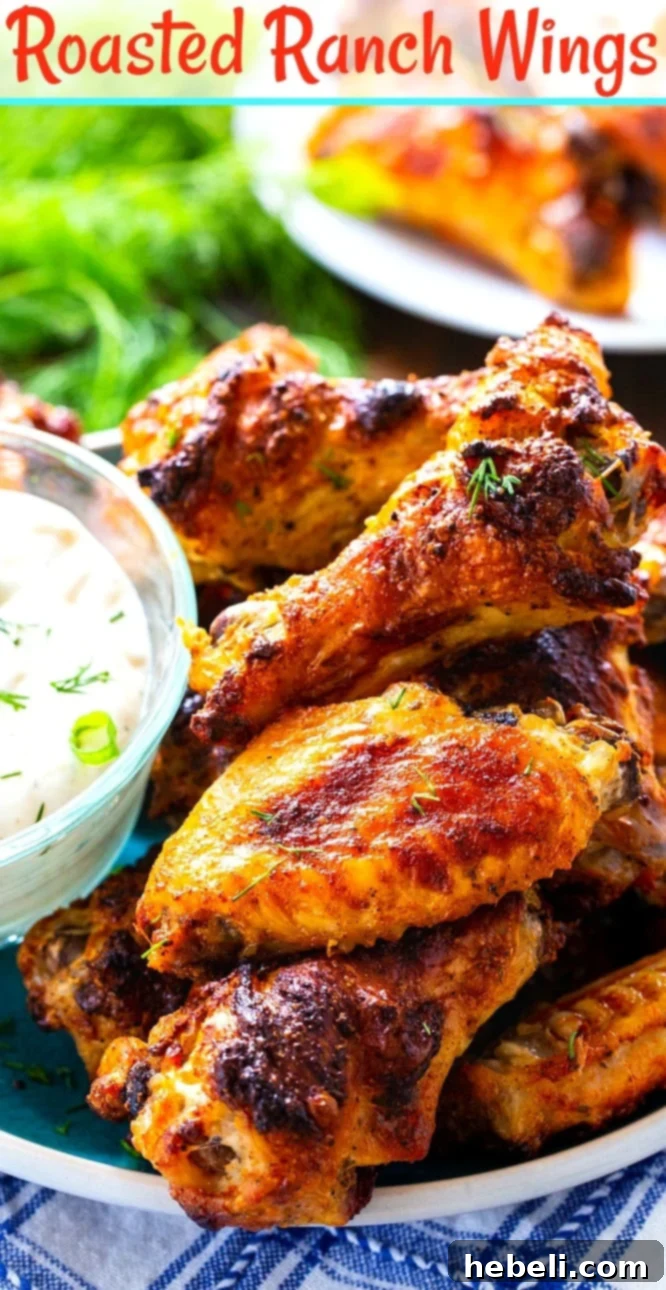 Close-up of wings piled up on plate with bowl of Ranch.