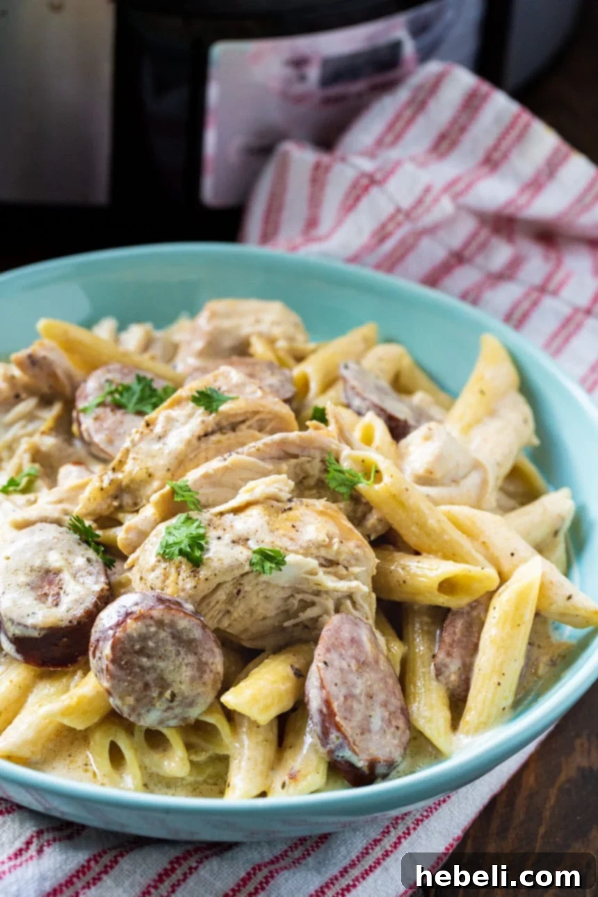 Alfredo Pasta with Chicken and Sausage in a blue bowl, ready to be enjoyed.