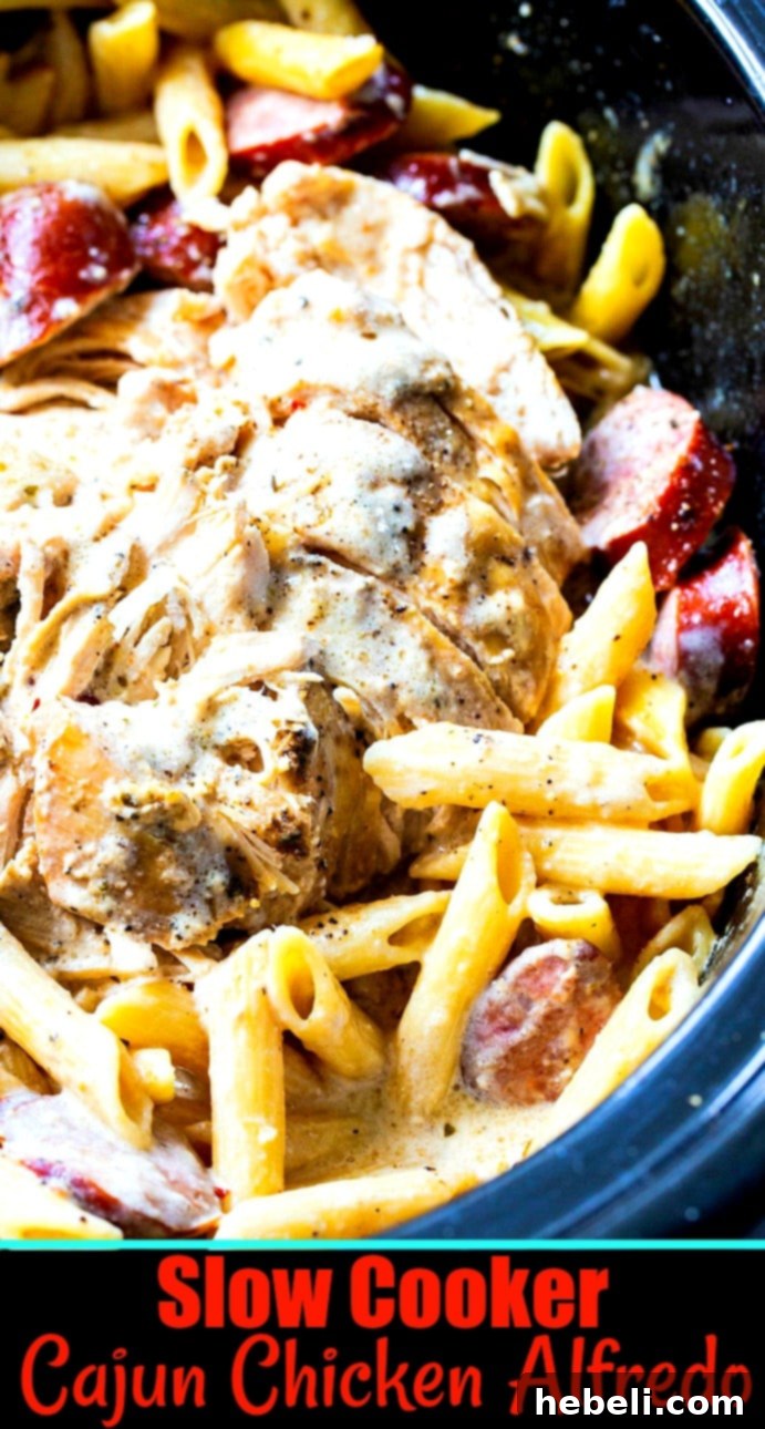 Close-up of chicken alfredo in a black crock pot, with a serving spoon.
