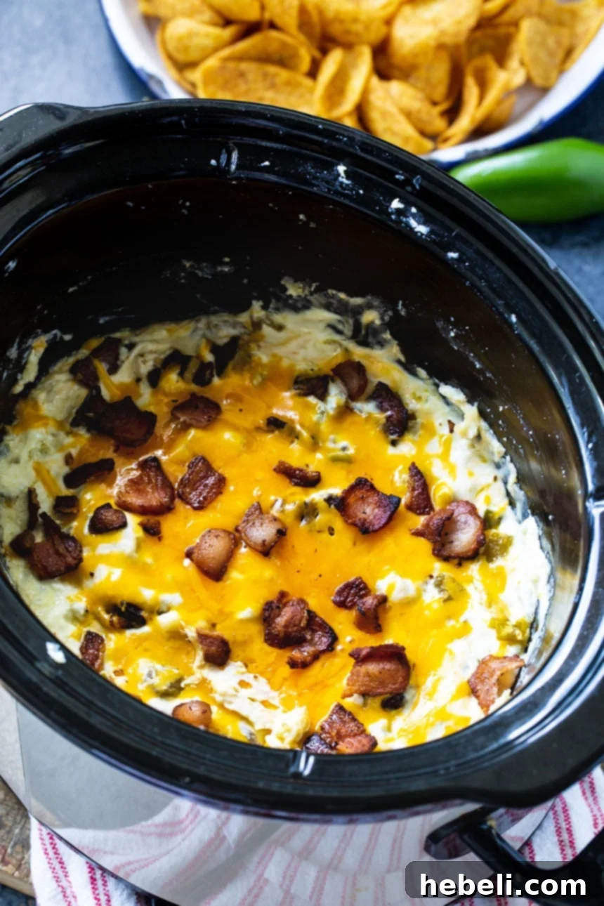 Ultimate Slow Cooker Jalapeno Popper Dip 3 The creamy Slow Cooker Jalapeno Popper Dip simmering to perfection inside a slow cooker, ready to be enjoyed.