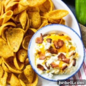 Close-up of creamy Slow Cooker Jalapeno Popper Dip with corn chips, ready for serving.