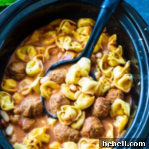 Hearty Slow Cooker Meatball and Tortellini Soup with tender meatballs and cheesy pasta in a crock pot.