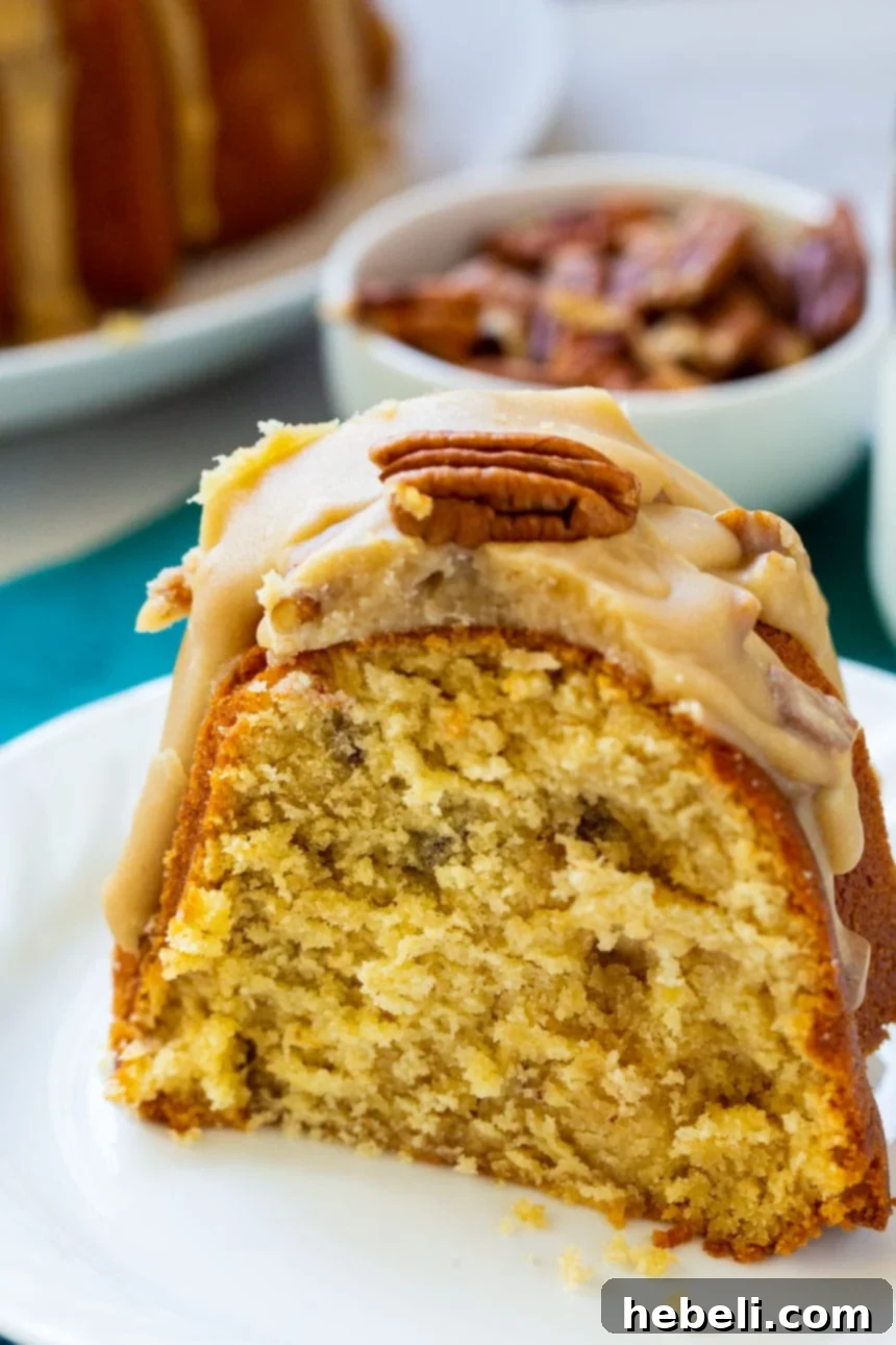 Southern Pecan Praline Bundt Delight 4 A delectable slice of Southern Praline Bundt Cake on a small white plate, showing the rich icing.