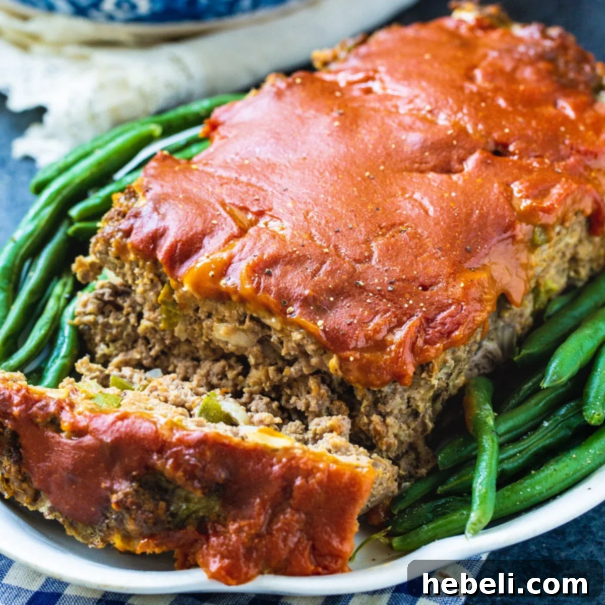 Classic Homestyle Meatloaf 2 Old-School Meatloaf on a serving platter with a side of fresh green beans.