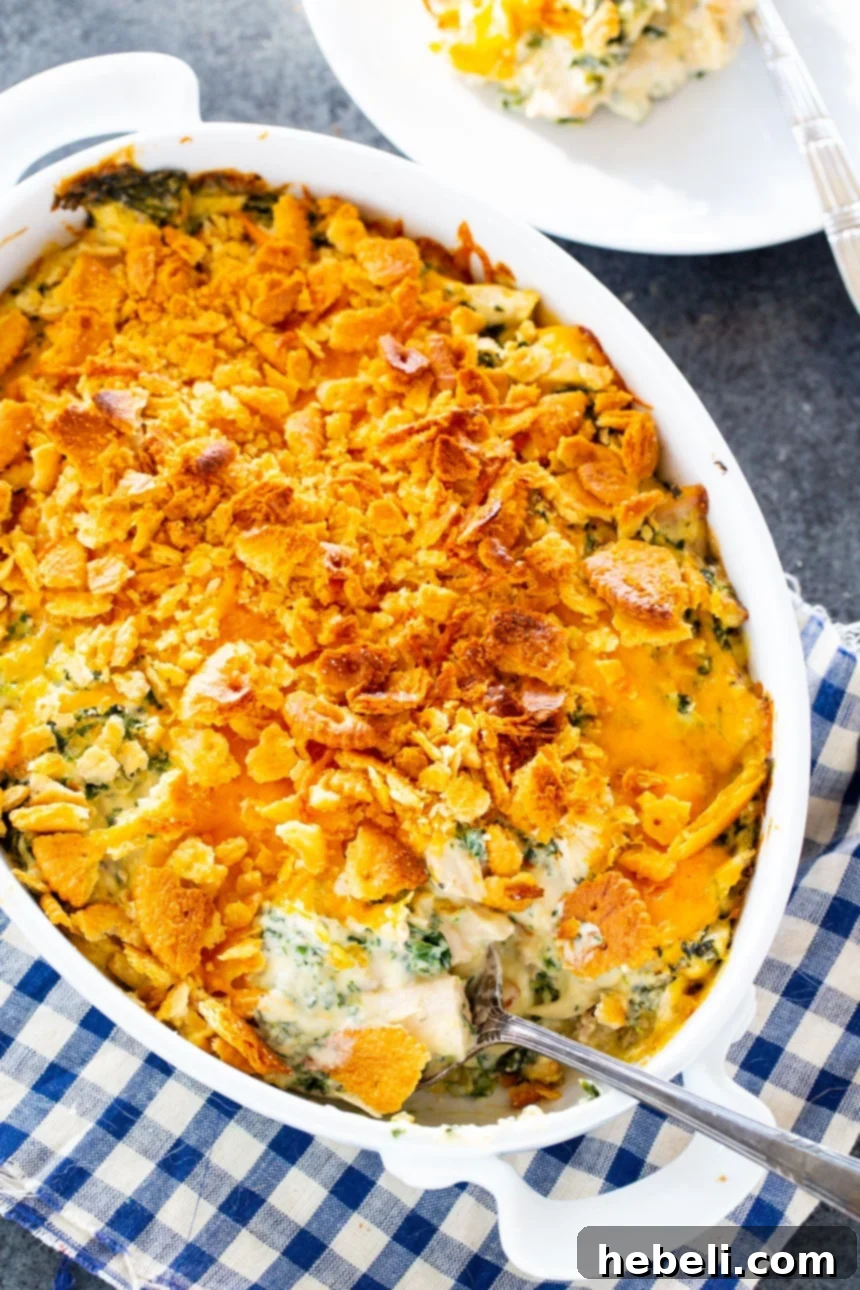 Effortless Chicken Spinach Bake 3 Close-up of the Easy Chicken and Spinach Casserole baking in an oval dish, showing the bubbly, cheesy topping.