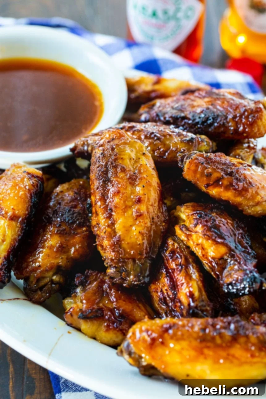 A close-up of beautifully glazed Honey TABASCO Wings, highlighting their golden-brown skin and sticky coating.