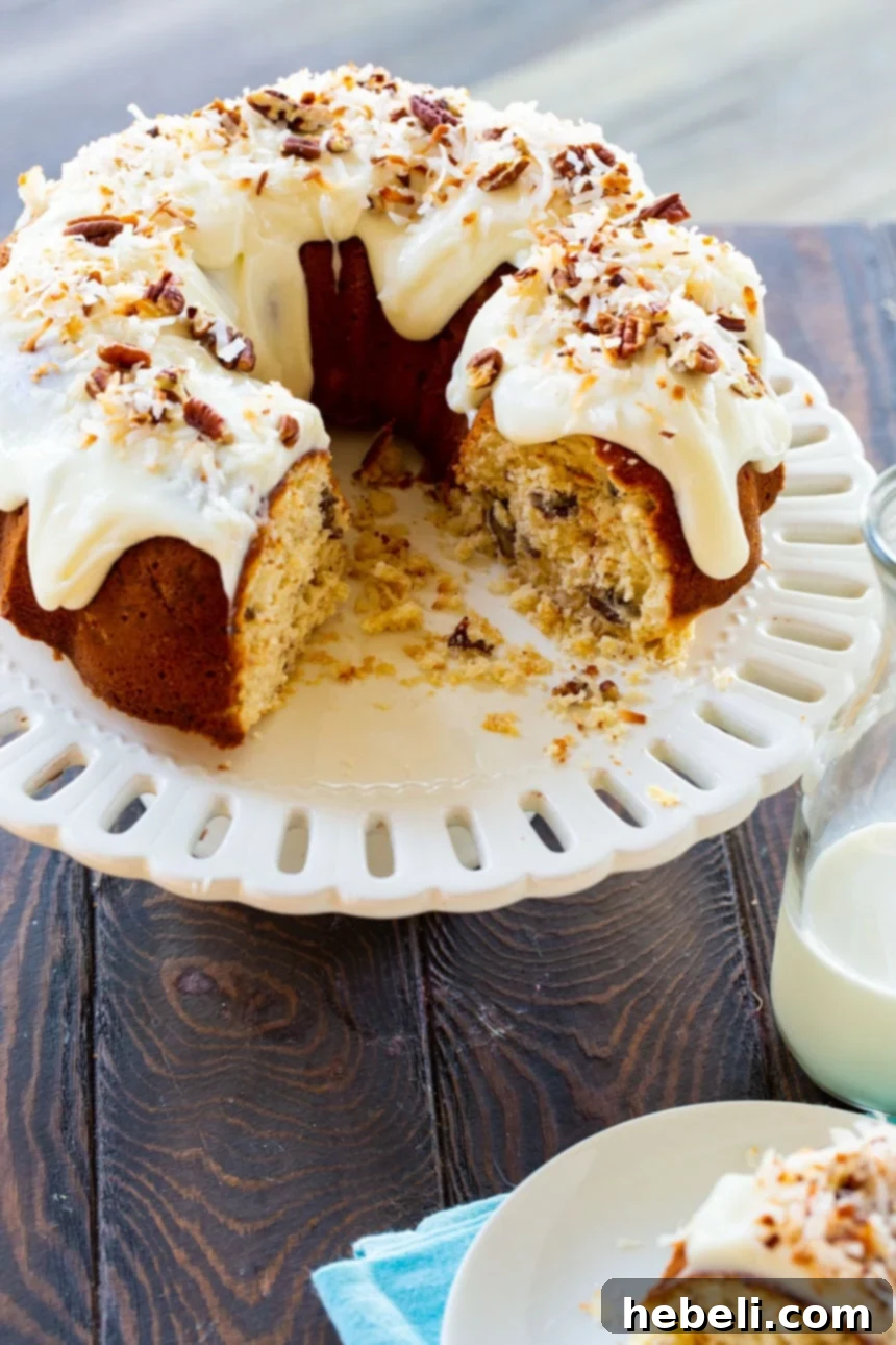 Decadent Italian Cream Bundt Cake 3 A perfectly baked Italian Cream Bundt Cake with several slices already removed, showcasing its moist interior.