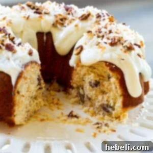 Decadent Italian Cream Bundt Cake 5 Moist Bundt Cake with cream cheese glaze on a cake stand, ready to be enjoyed.