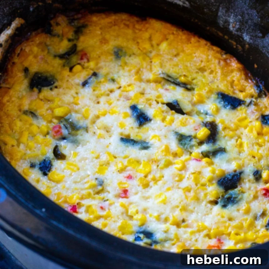 Creamy Slow Cooker Southwestern Corn Casserole simmering in a crock pot, ready to be served as a flavorful side dish.
