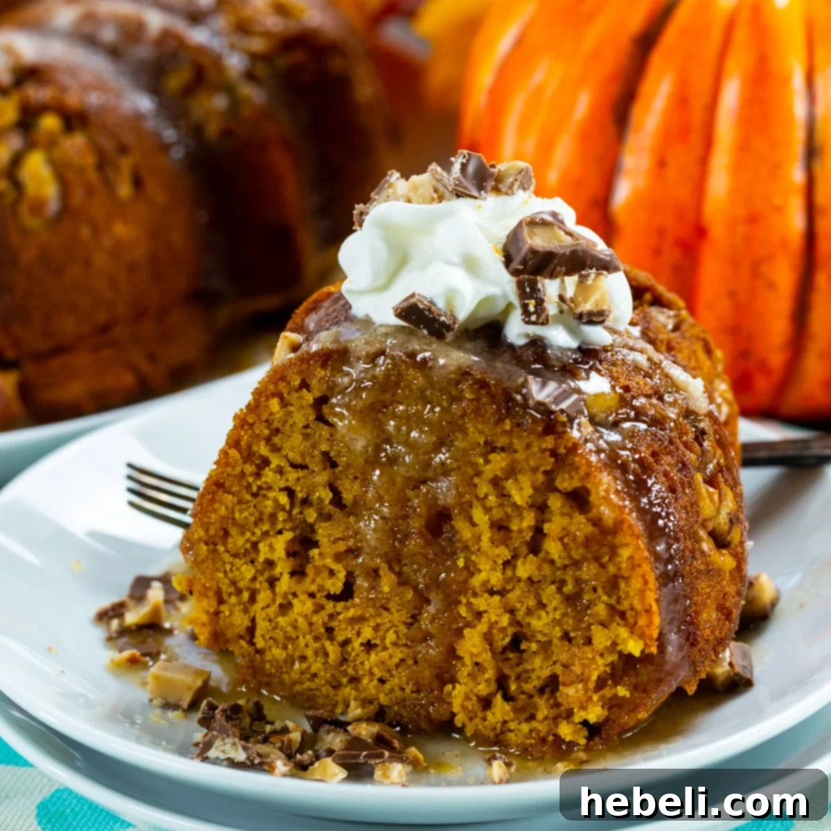 A slice of moist Pumpkin Cake with Rum Glaze on a plate, showing its rich texture and inviting golden glaze.