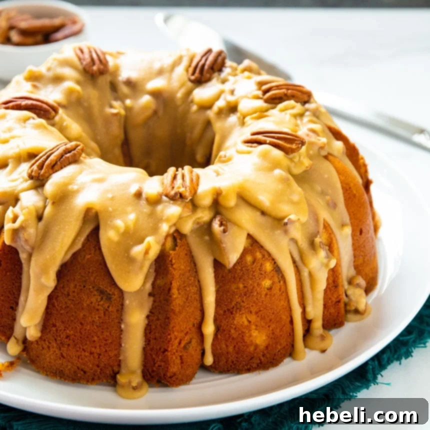 A Southern Praline Bundt Cake, generously covered with a rich praline sauce, displayed on a large white serving platter.