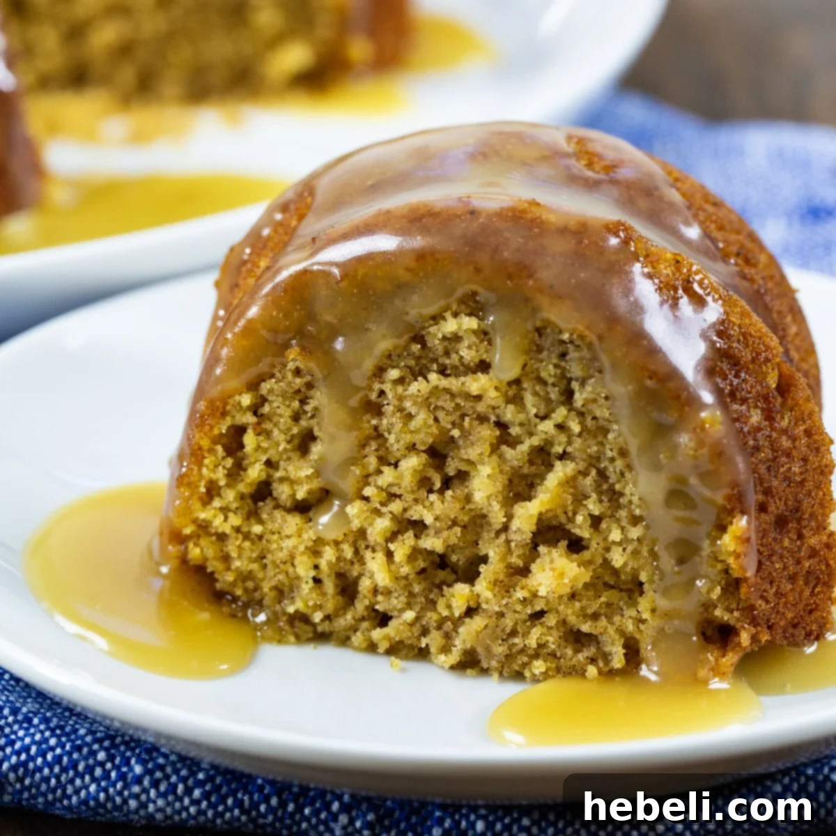 A beautiful Butternut Spice Cake with Bourbon Glaze, on a rustic cutting board, sliced and ready to be served.